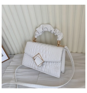 Detail of white crocodile pattern bag with ruched handle and gold diamond buckle