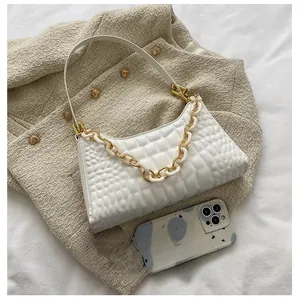 Detailed view of white quilted shoulder bag capacity with golden chain and phone comparison