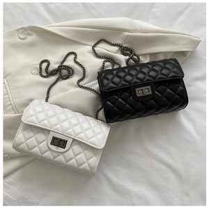 Detailed view of quilted leather texture and metal chain strap on two cross-body bags