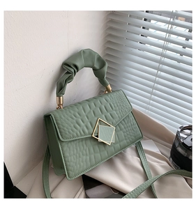 Detail of green faux-leather bag with crocodile texture and pleated cloud handle