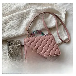 Pink quilted crossbody bag with gold chain strap shown next to a smartphone for size