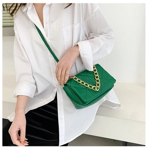 Détail du sac bandoulière en cuir matelassé vert émeraude avec grosse chaîne dorée