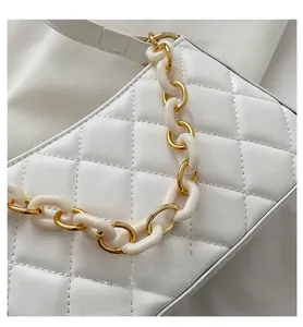 Détail du sac en cuir matelassé blanc avec chaîne en résine blanche et métal doré