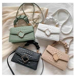 Detail view of four pleated tote bags showing crocodile patterns and golden metal locks