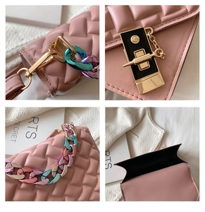 Detail of pink woven PU leather handbag showing gold S-lock and acrylic chain strap