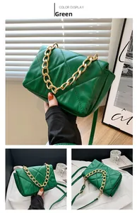 Gros plan du sac bandoulière vert matelassé avec une chaîne dorée et une lanière cuir