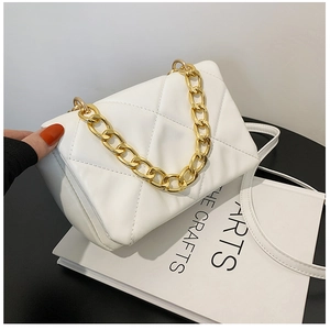 Détail du sac matelassé blanc avec bandoulière chaîne dorée et texture cuir