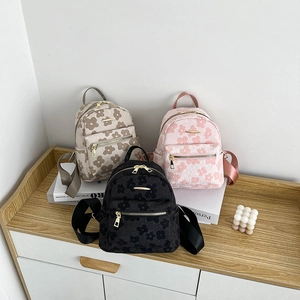 Mini sac à dos en toile pour femme en noir, rose et beige avec motifs floraux gaufrés