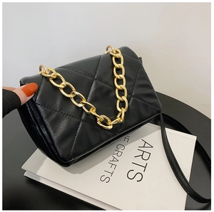 Détail du petit sac noir matelassé avec chaîne dorée épaisse et bandoulière en cuir