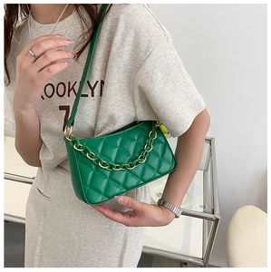 Détail du sac à bandoulière matelassé vert avec chaîne dorée pour un look élégant