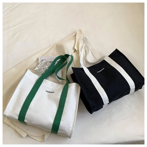 Still life view of fashion canvas tote bags in green and black contrast with fashion print