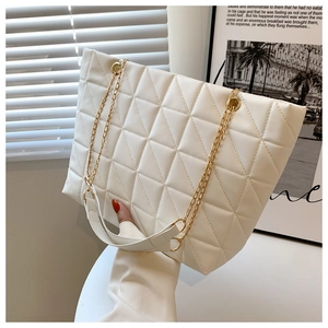 Détail du sac cabas matelassé blanc avec chaîne dorée et texture élégante en simili cuir chic