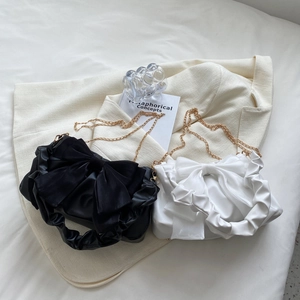 Elegante borsa con fiocco in nero e bianco con dettagli pieghettati e catena dorata