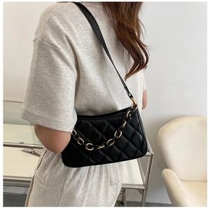 Détail du sac matelassé noir avec chaîne dorée et fine bandoulière en similicuir
