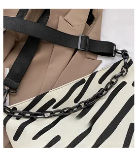 Detail of zebra stripe canvas tote with black decorative chain and nylon strap