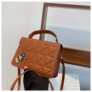 Close-up of brown quilted crossbody bag with golden buckle and sleek leather texture