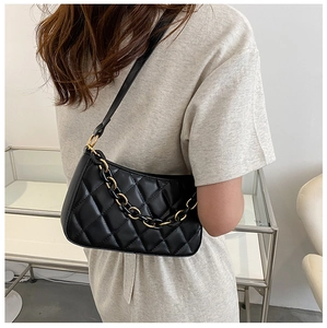 Détail du sac à bandoulière matelassé noir en similicuir avec chaîne dorée sur mannequin