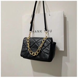Détail du sac matelassé noir avec chaîne dorée et texture en similicuir de haute qualité