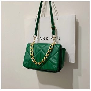 Détail du sac bandoulière vert matelassé avec chaîne dorée et coutures losanges