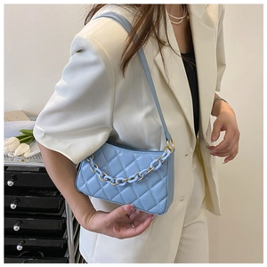 Vue latérale du sac porté épaule bleu clair matelassé avec détail de chaîne élégante