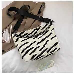 Detailed view of striped canvas tote bag size comparison with a mobile phone