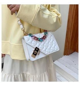 Close-up of white quilted handbag with a colorful rainbow chain and gold metal buckle