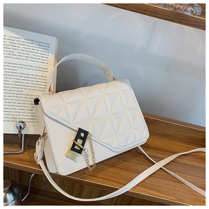 Detail of white quilted crossbody bag with gold-tone twist lock and chain strap