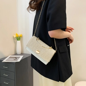 Chic woven patchwork crossbody bag with gold chain strap shown in a modern home setting