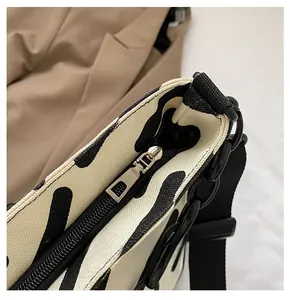 Detail of smooth metal zipper and zebra stripe pattern on a canvas tote bag