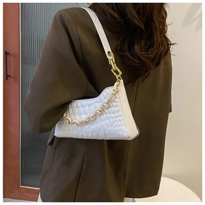 Detailed view of white crocodile pattern shoulder bag with decorative gold chain and strap