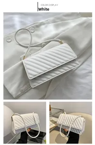 Detailed view of a white quilted crossbody bag with V-shaped stitching and gold hardware