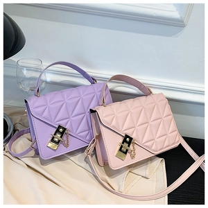 Detail of purple and pink quilted handbags with metal twist locks on silk fabric