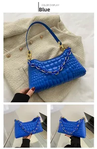 Close-up of blue baguette bag featuring checkerboard texture and chunky chain detail