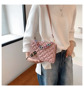 Detail of pink quilted handbag with colorful resin chain and golden metal twist lock