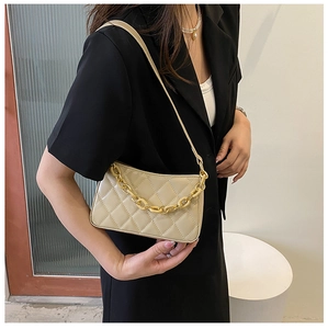 Détail du sac beige matelassé avec chaîne dorée et motif élégant de losanges brodés