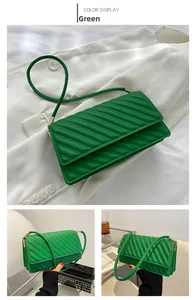 Detailed view of green quilted leather bag with V-shaped stitching and gold metal hardware