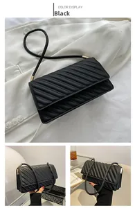Detail of black quilted shoulder bag with gold hardware on white background and hand-held view