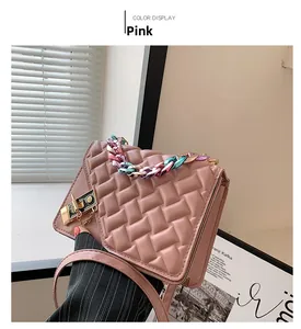 Detailed view of pink textured PU handbag with colorful metal chain and golden twist lock