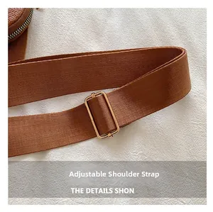 Detail of adjustable caramel woven shoulder strap with polished gold metal hardware buckle