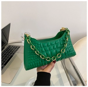 Close-up of vibrant green baguette bag with textured faux leather and chunky gold chain