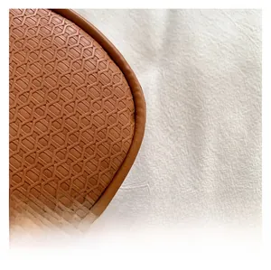 Detailed close-up showing the brown geometric honeycomb embossed texture of the bag material