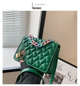 Detailed close-up of dark green woven leather handbag with gold clasp and chain strap
