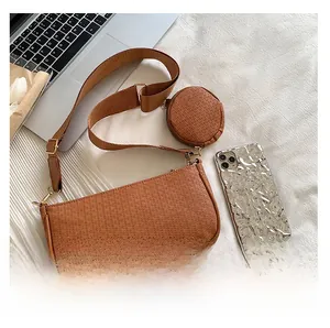 Detail of brown embossed leather baguette bag with wide strap and round coin purse