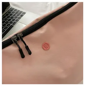 Detail of pink waterproof nylon laptop bag with smooth dual zippers and E-logo