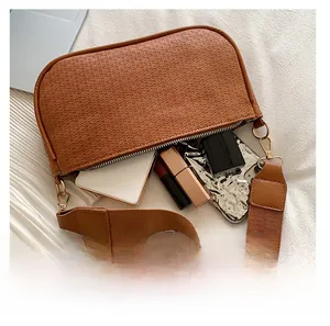 Internal view of brown woven handbag showing capacity for phone and cosmetics