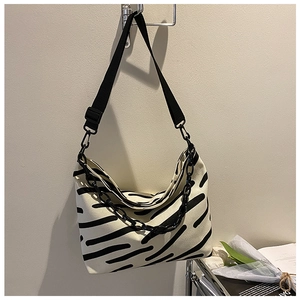 Detail of zebra pattern canvas tote bag with woven strap and decorative chain link