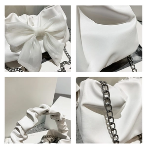Détails du sac blanc avec nœud en maille, bandoulière chaîne et texture grainée