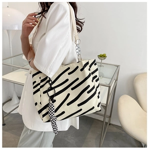 Detail shot of striped canvas tote bag with chain strap and checkered silk scarf accessory