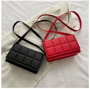 Detail of red and black quilted square bags with lattice patterns and thin shoulder straps