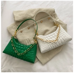 Detail of quilted leather baguette bags with chunky gold chains and beige tweed texture